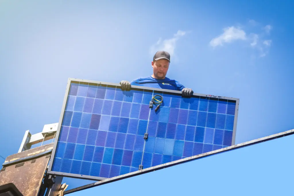 Monteur der Sonnen-Energie bei der Montage eines Solarmoduls